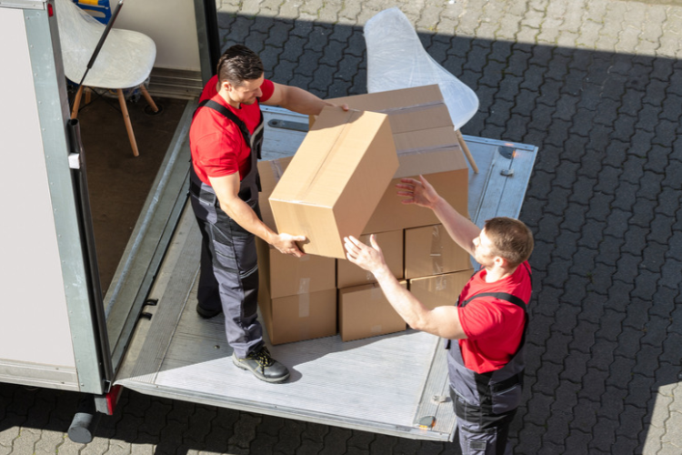 Two men loading a Luton van with tail lift