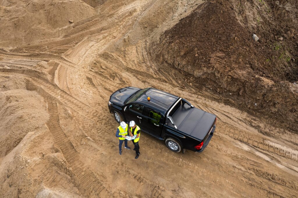 Two construction workers next to a pickup truck