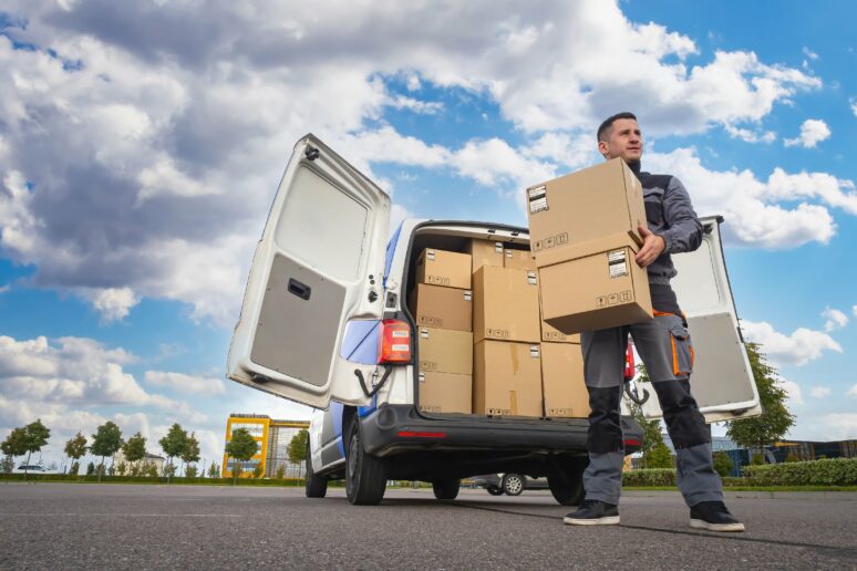 Small-van-hero-image Man unloading boxes from a small van