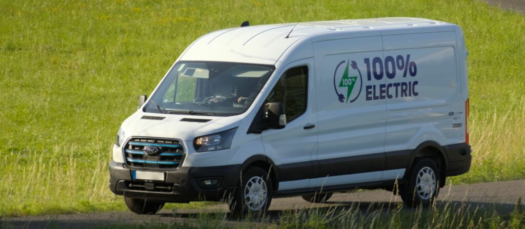 Ford e Transit van driving through a green field