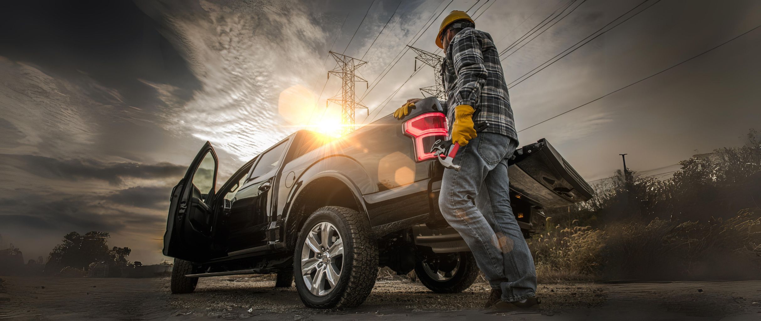 Workman standing next to a double cab pickup truck