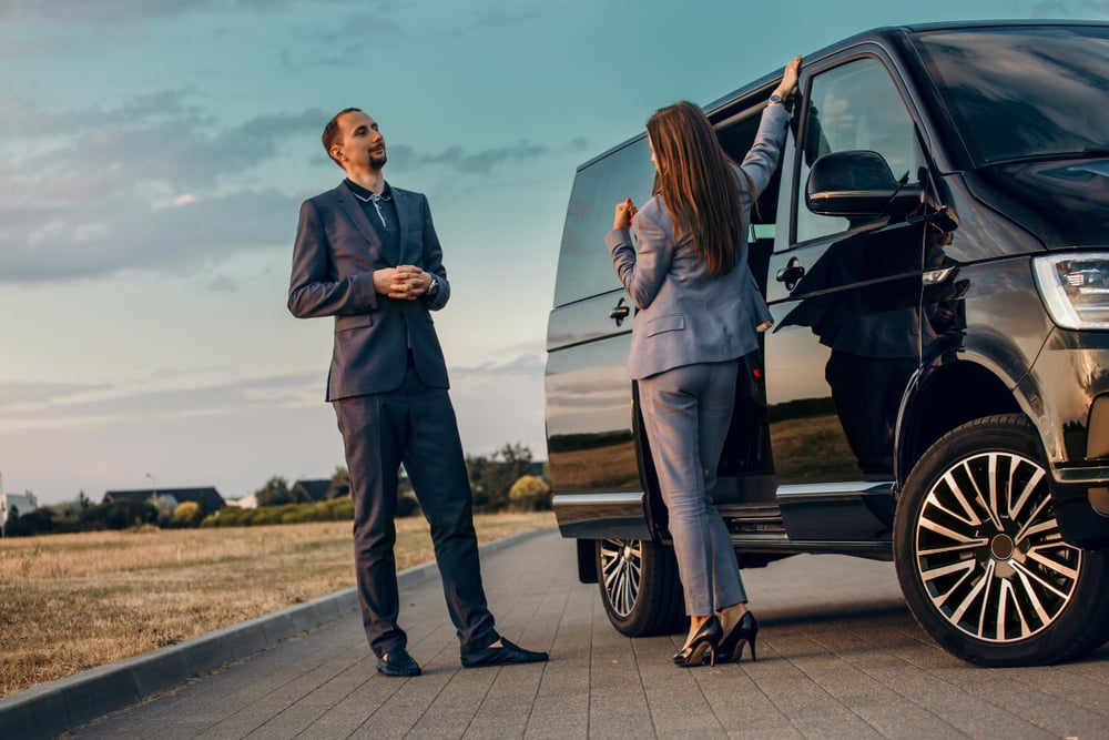 People standing next to a black van