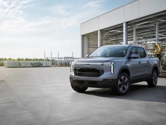 Illustrative compact electric pickup concept outside a modern vehicle manufacturing facility.